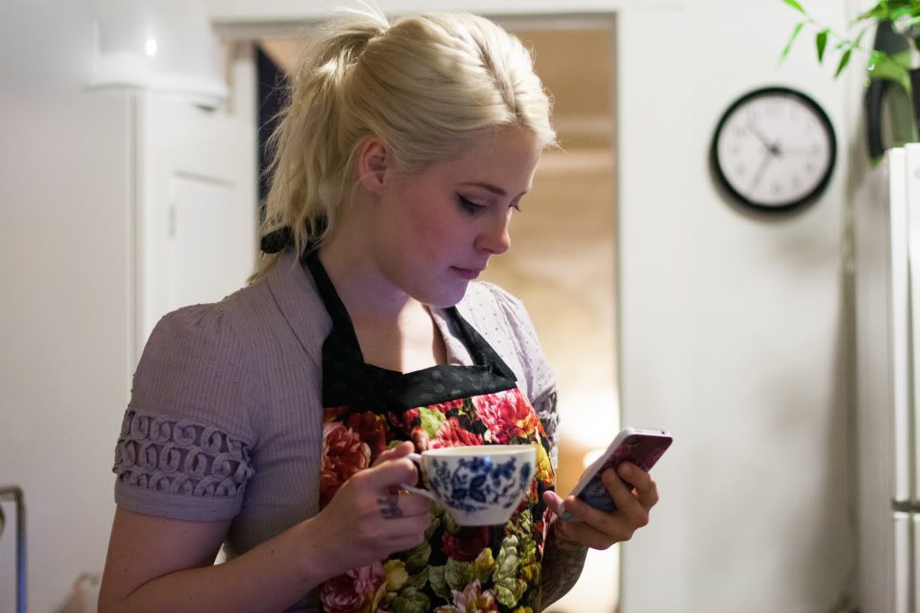 Jessican in the kitchen with teacup and apron